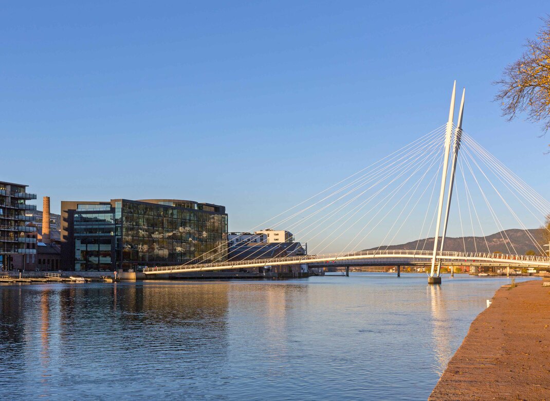 Ypsilon bruen, elven og bygninger langs elven. Foto.